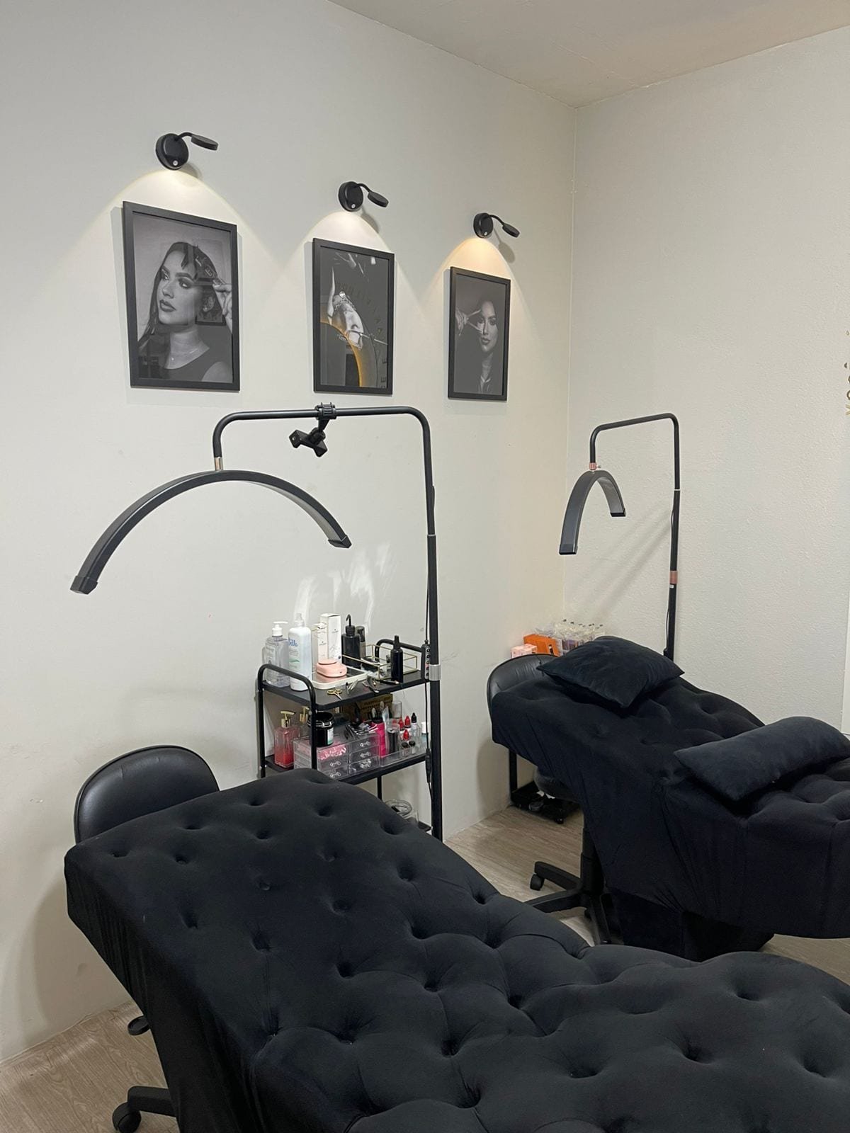 Sala de atendimento com poltronas pretas e quadros autorais em preto e branco