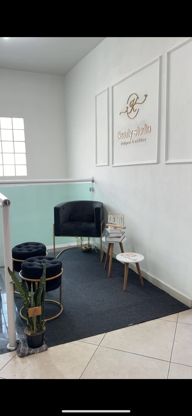 Recepção com poltrona preta e identidade Beauty Studio
